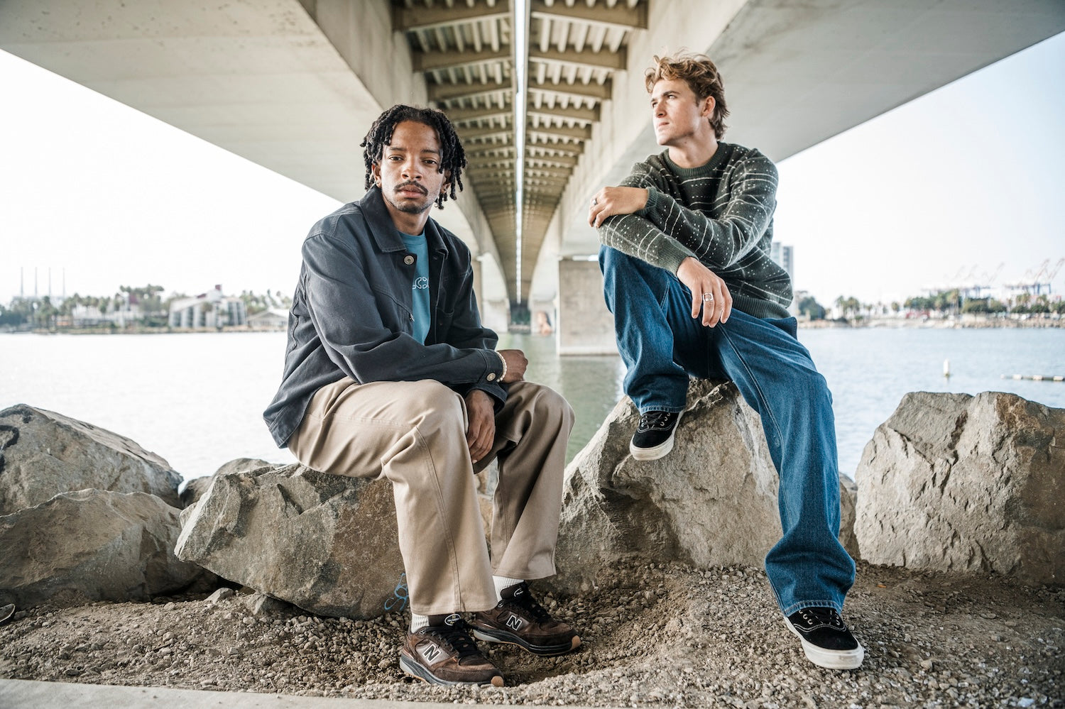 Two men sitting on a stone step in button ups and chinos