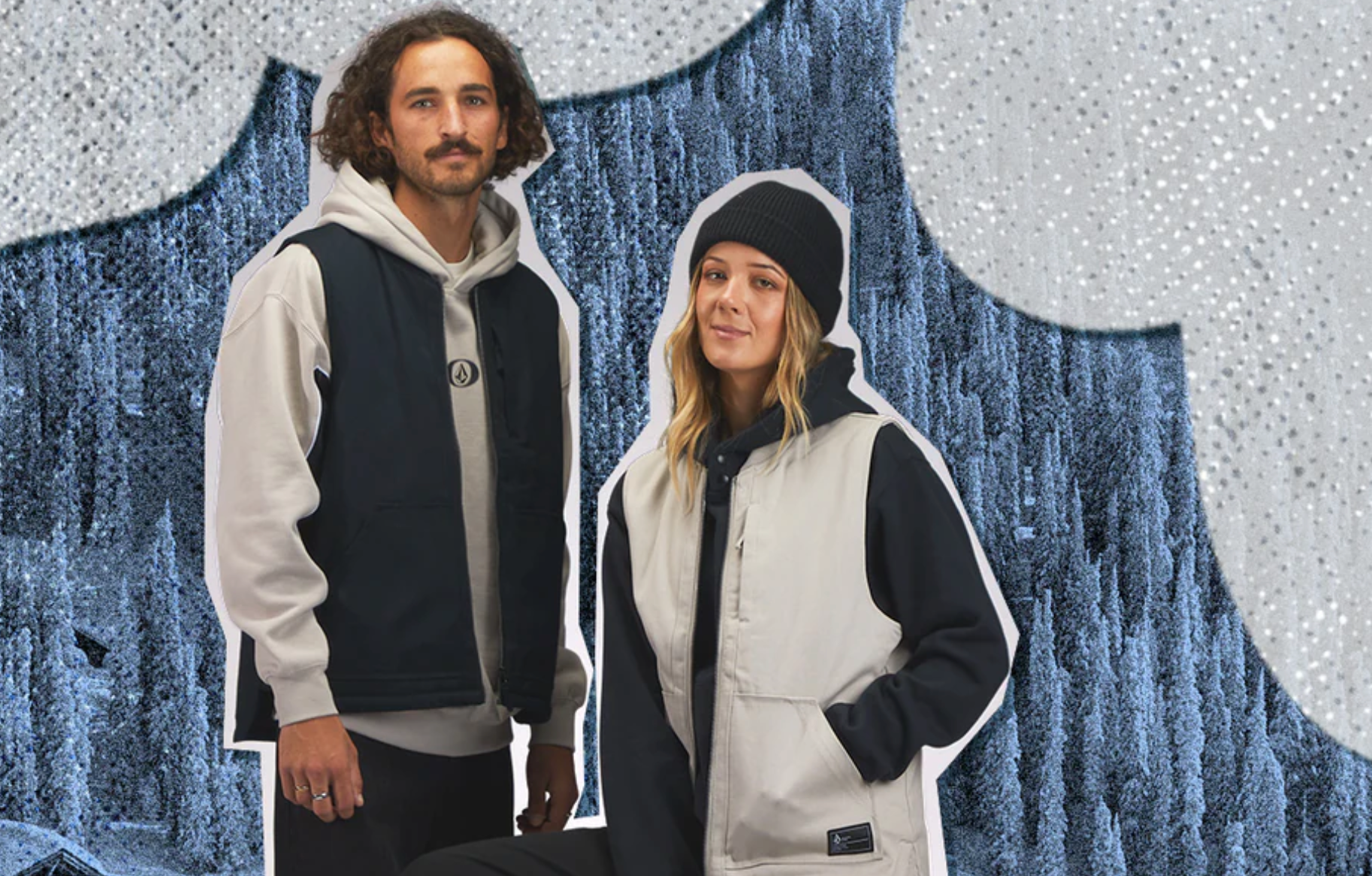 A man and a woman in winter clothing pose in front of a snowy, illustrated backdrop with trees and white, cloud-like shapes above.