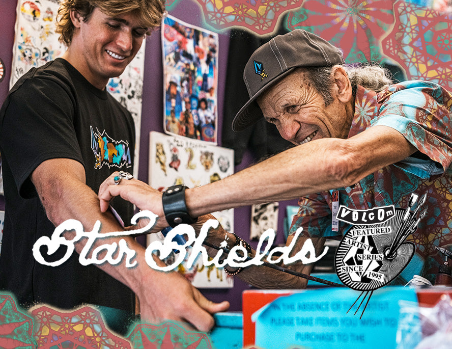 Two men smile as one receives a tattoo on his arm in a colorful studio decorated with art. The words Star Shields and a Volcom Featured Artist badge are overlaid on the image.