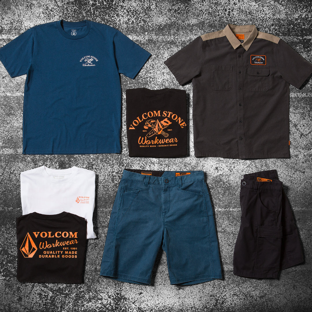 Flatlay of different colored shirts and pants on a grungy background