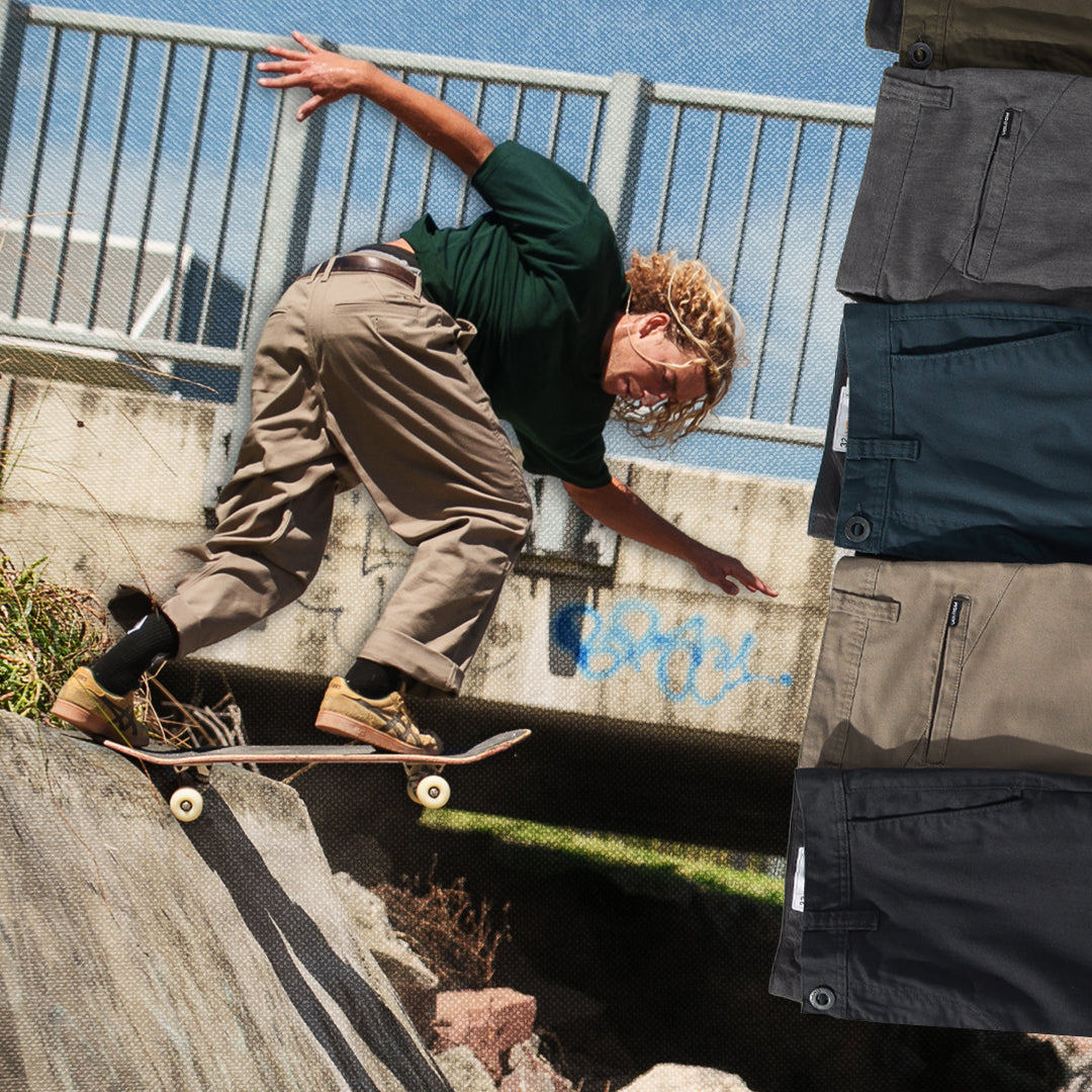 Person skateboarding on a concrete ledge with a metal railing and blue sky in the background