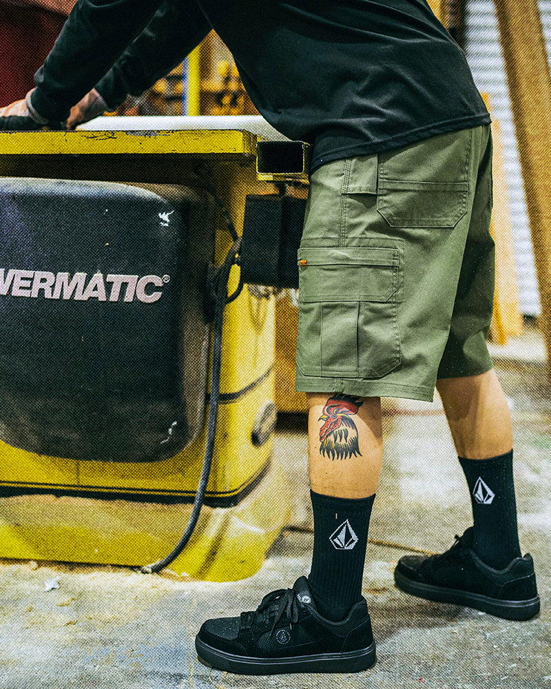 a person wearing gage shorts working with machines