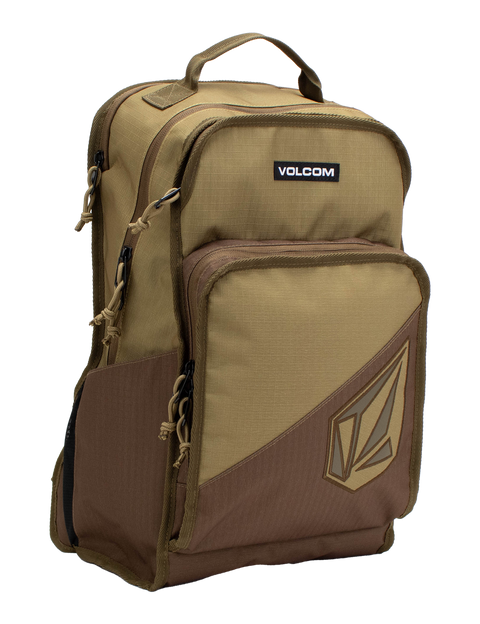 The Volcom Men's Boundary Backpack in brown and tan features multiple zippered compartments, a top handle, and a spacious front pocket with the Volcom logo. Designed for durability, this backpack includes a convenient laptop compartment, making it ideal for everyday use or travel.