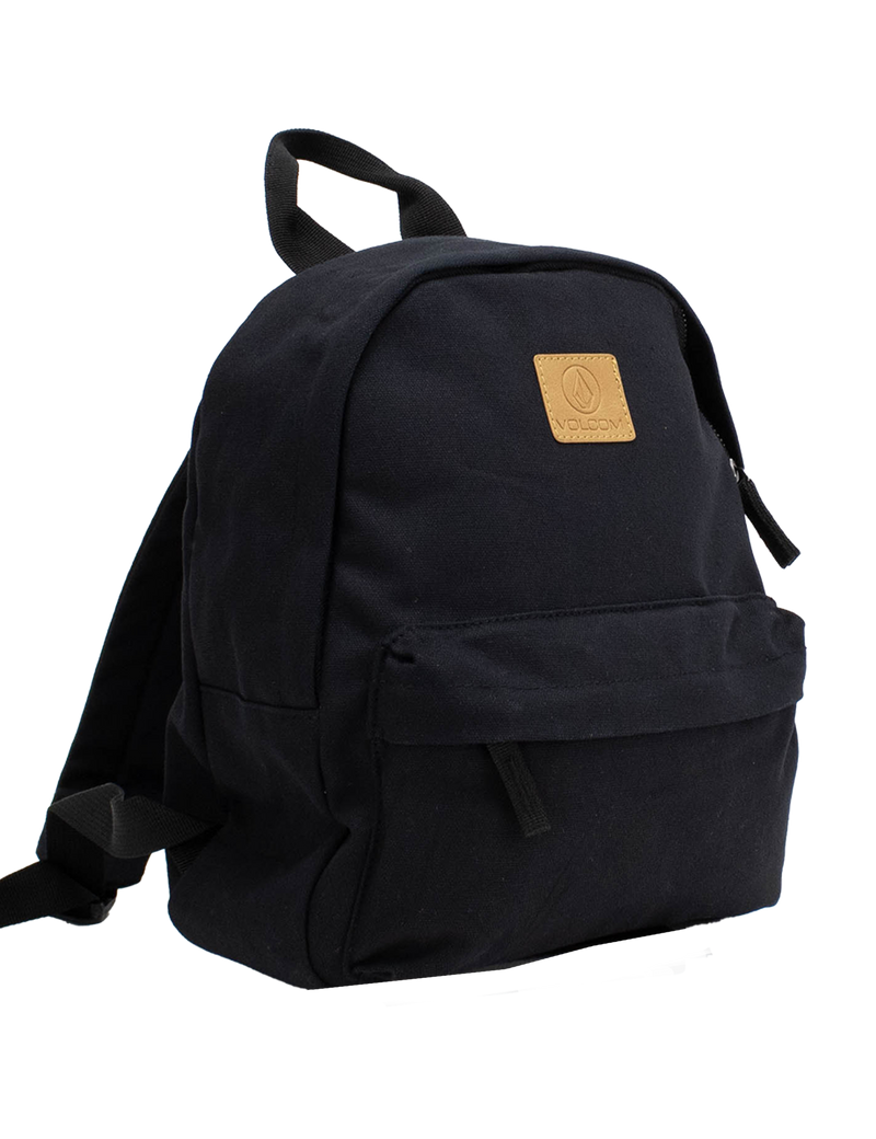 The Women's Winnie Backpack by Volcom is a minimalist black backpack with black straps, a front zip pocket, and a tan leather Volcom patch logo on the upper front, displayed against a plain white background.