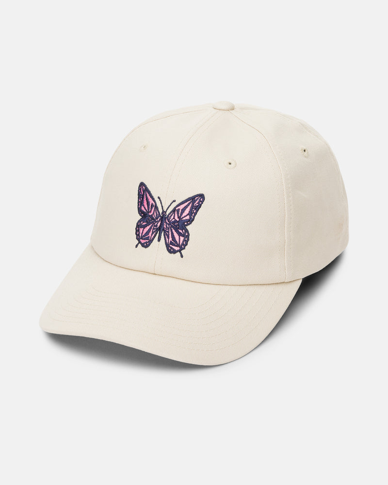 The Women’s Stone Rising Hat by Volcom is a beige, 6-panel unstructured cap with an adjustable strap back for a comfortable fit. Featuring an embroidered purple and black butterfly design on the front, this hat is photographed against a white background.