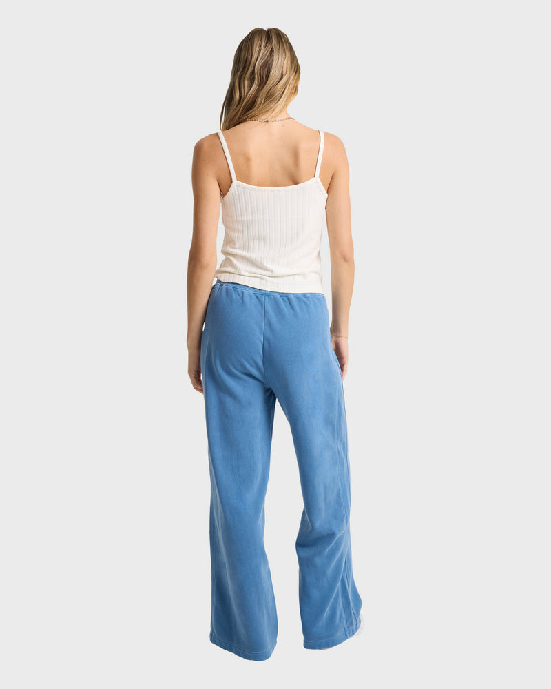A woman in blue pants pairs them with the Volcom Women's Lived In Rib Tank for a stylish, effortless look.