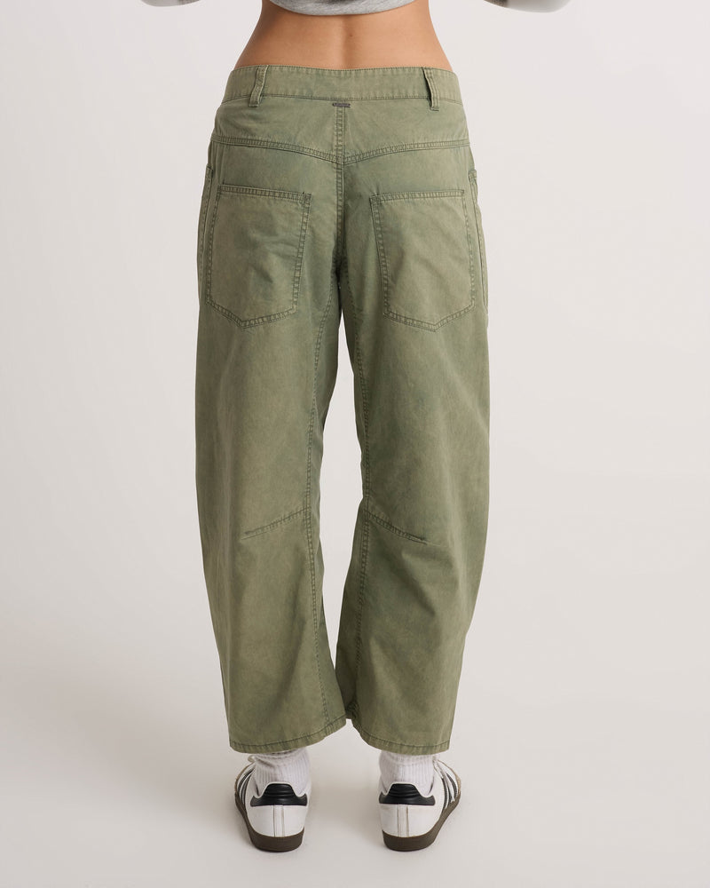 Back view of Volcom Women’s Patchwork Pants in olive green, featuring a utility-cool wide-leg fit, large back pockets, and paneling on the legs.