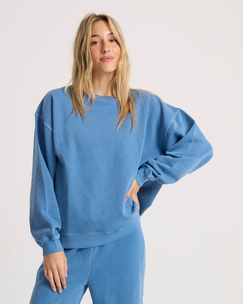A woman wearing a Volcom Women’s Stone Soft Crew, a relaxed dropped-shoulder crewneck sweatshirt in washed fleece.