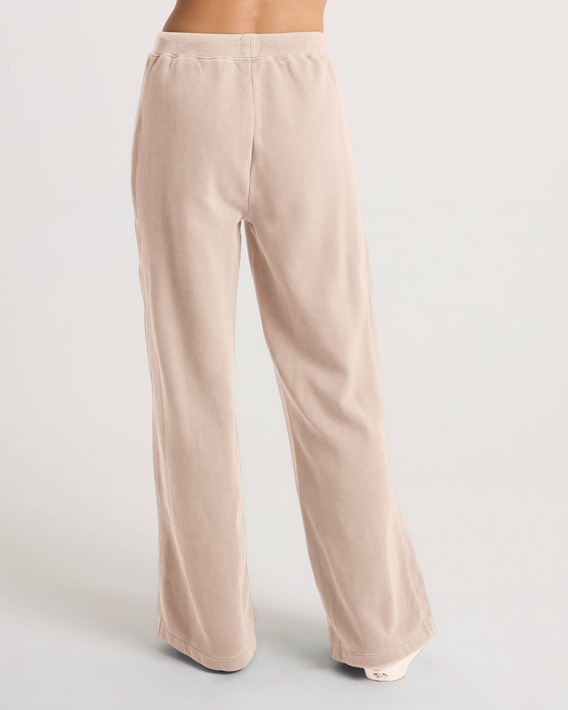 Rear view of a person wearing beige Volcom Women’s Stone Soft Pant, featuring a loose-fit, pull-on, wide-leg design.
