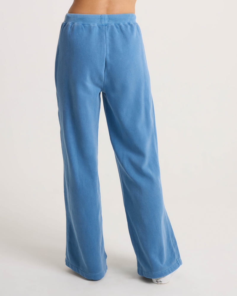 Back view of a person wearing blue Volcom Women’s Stone Soft loose-fit lounge pants with an elastic tie-front waistband.