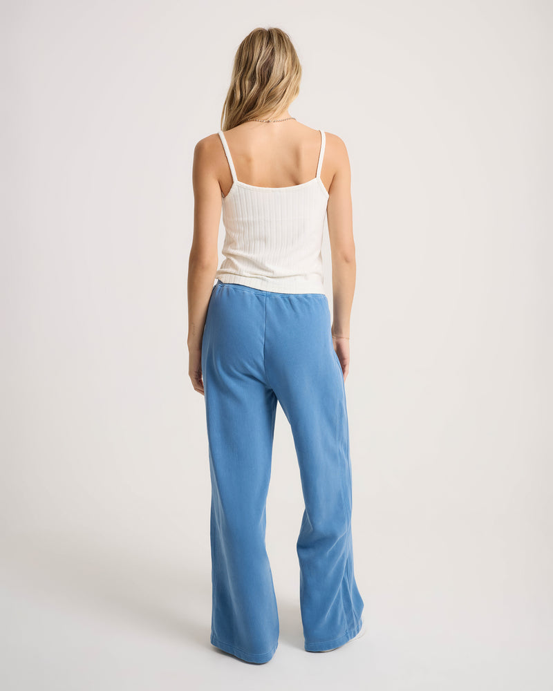 A woman seen from behind, wearing a white ribbed camisole and Women’s Stone Soft Pant, which are loose-fit, washed fleece sweatpants with a tie-front waist.