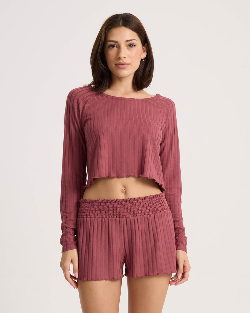 Woman wearing a long-sleeved, ribbed, cropped top and matching stone rose Women’s Sun Lounge Short.