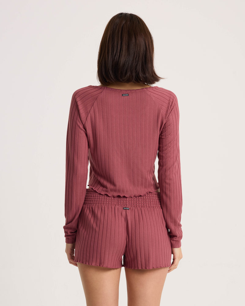 Back view of a person wearing a matching mauve ribbed long-sleeved top and Women’s Sun Lounge Short with a smocked waistband.