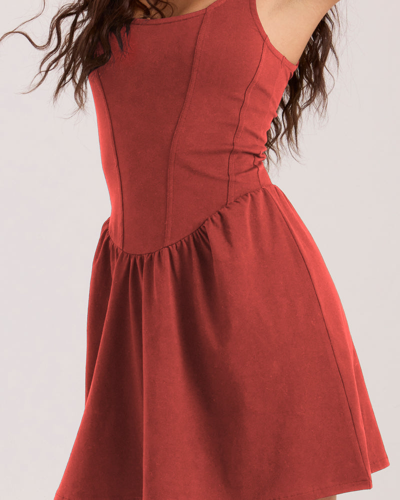 A sleeveless red Volcom Women’s Carve Dress in an A-line mini silhouette featuring a fitted, corset-style bodice and a flared, gathered skirt.