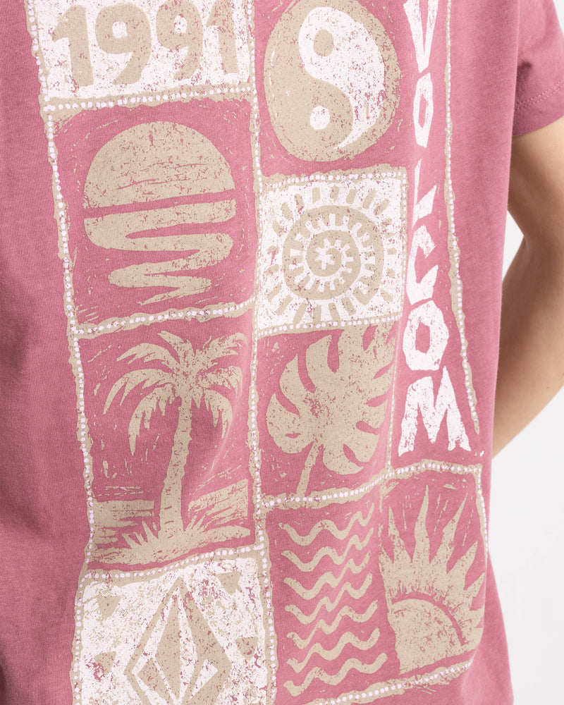A mauve, boxy, boyfriend-fit Women’s Volcom Stamp Lock It Up Tee featuring a grid of distressed cream-colored prints, including a palm tree, a sun, and the year 1991.