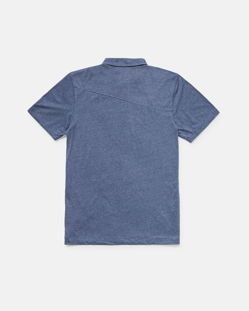 A men's Wowzer Polo Short Sleeve Shirt by Volcom in blue, shown from the back with a simple collar and diagonal upper-back seam, crafted from a cotton-poly blend and laid flat on a white background.
