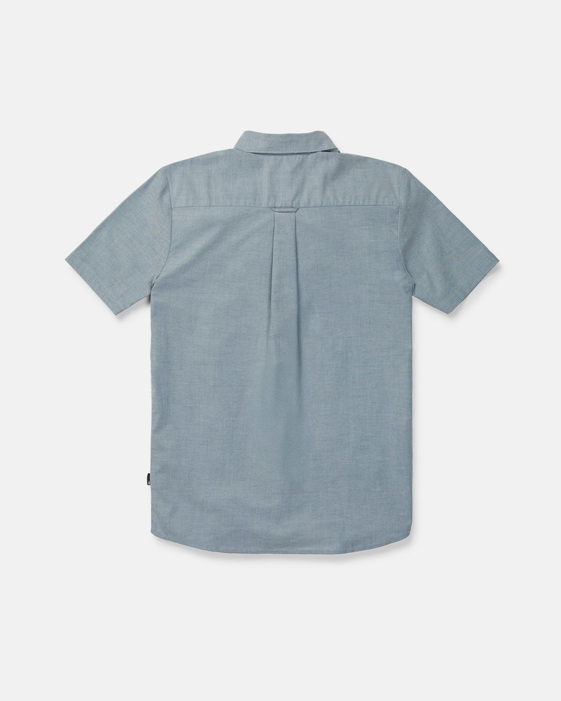 The Volcom Men's Everett Oxford II Short Sleeve Shirt is displayed from the back, highlighting its straight yoke, central pleat, and subtly curved hem. Crafted from lightweight, textured stretch-woven fabric for superior comfort, this classic fit button-up shirt is perfect for all-day wear.