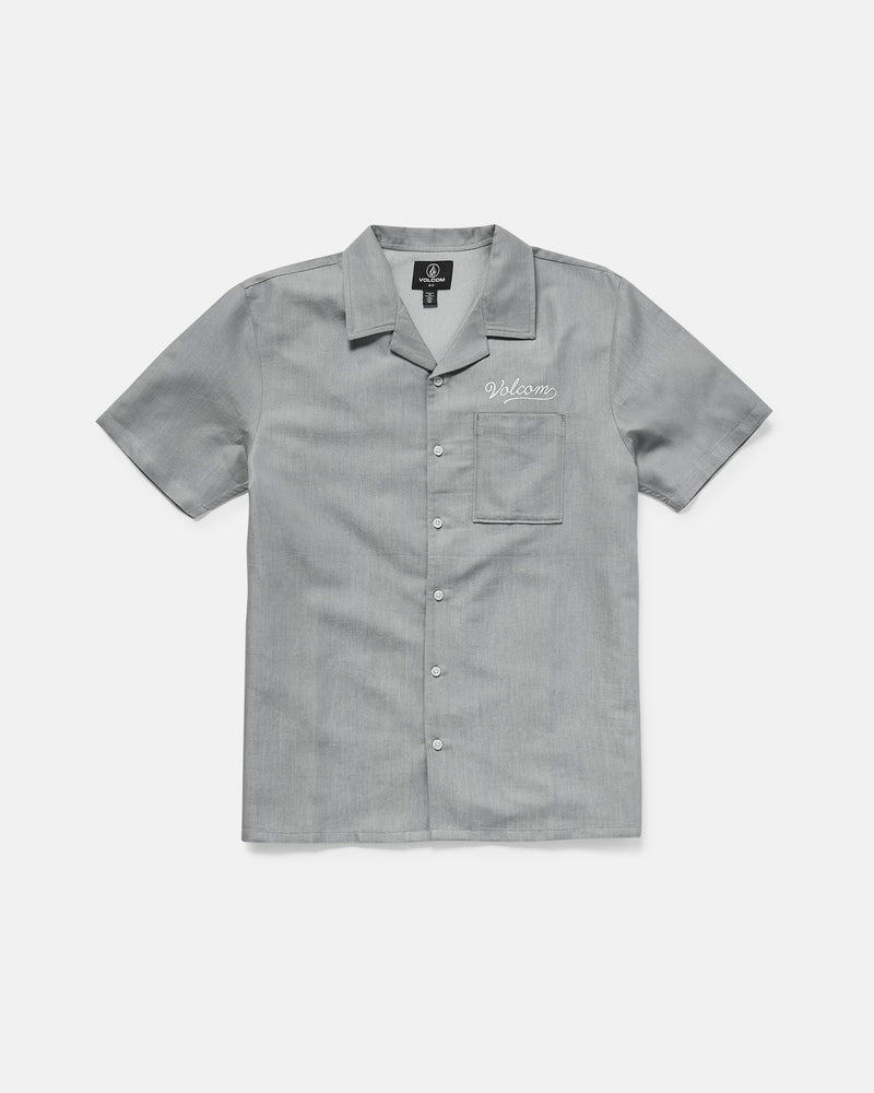 The Volcom Men's Otis Stone Short Sleeve Tee is a light gray, boxy-fit tee with a collar, made from textured fabric. It has a single chest pocket with "Welcome" embroidered above it in white.