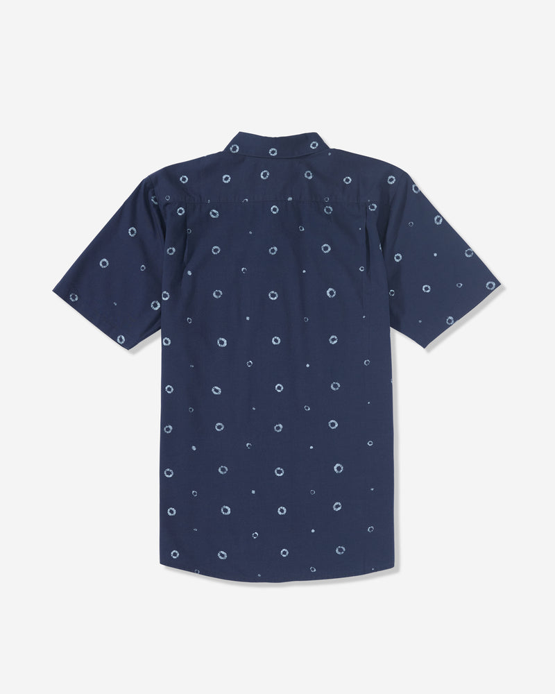 The Men’s Scaler Stone Woven Short Sleeve Shirt by Volcom is a navy blue collared shirt with an allover print of small white circular dots, shown from the back.