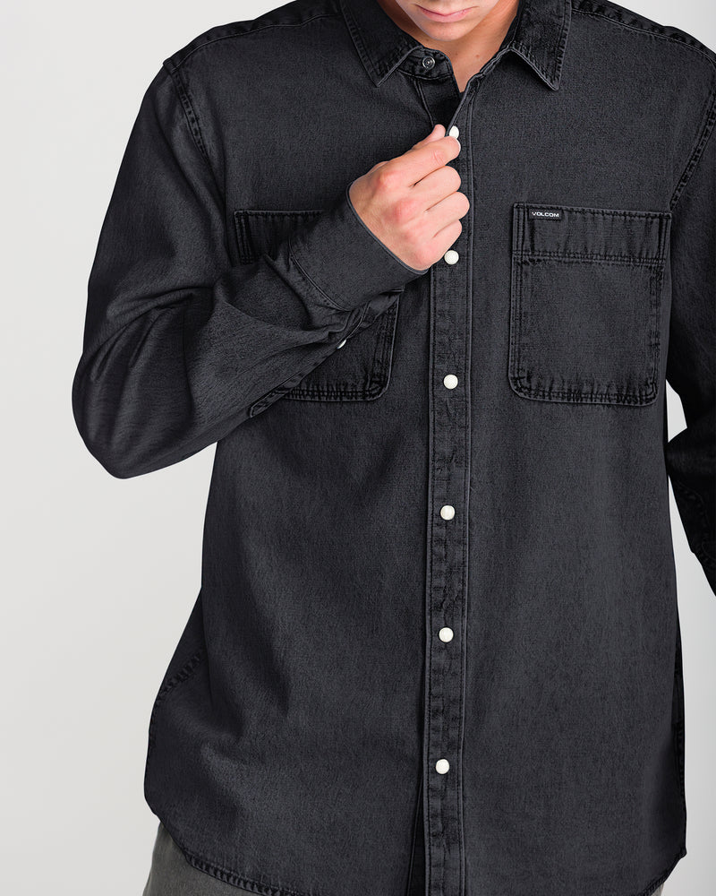 Volcom Men’s Goodwin Long Sleeve in a relaxed fit, black midweight denim with long sleeves and two chest pockets, worn with the top button fastened.