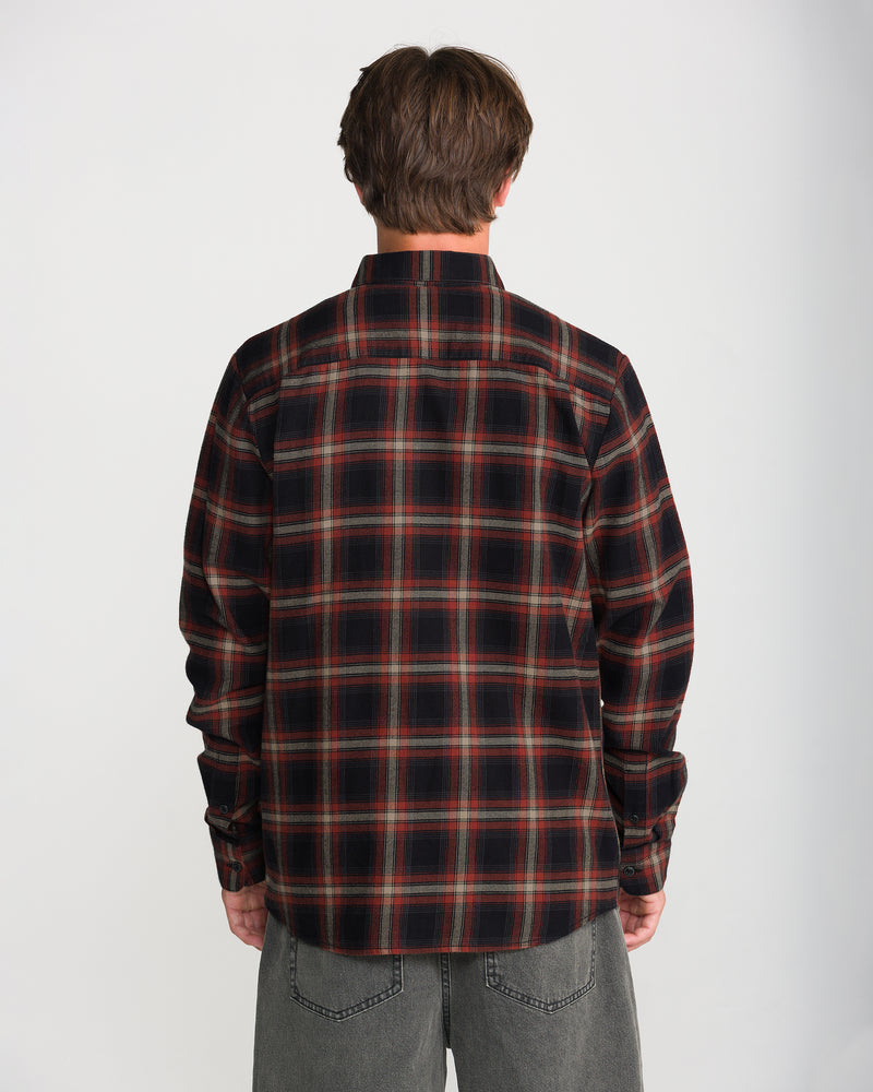 Back view of a person wearing a black and red plaid Volcom Men’s Caden Plaid Long Sleeve shirt.
