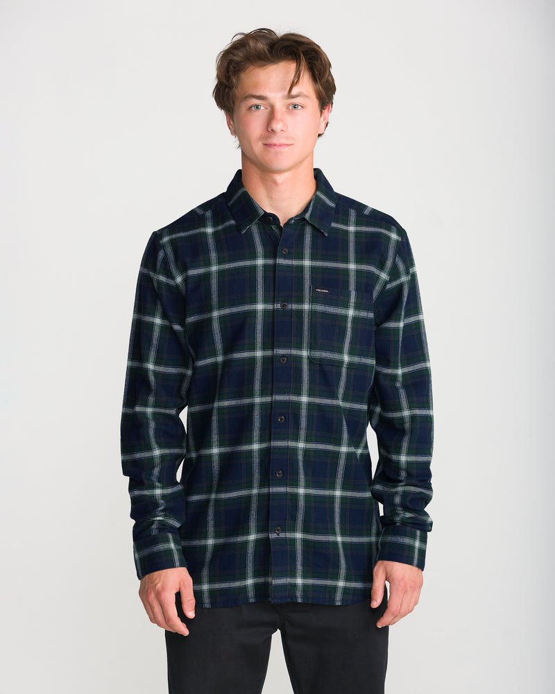 A man wearing a dark green and navy blue Men’s Caden Plaid Long Sleeve classic fit cotton flannel shirt with a chest pocket.