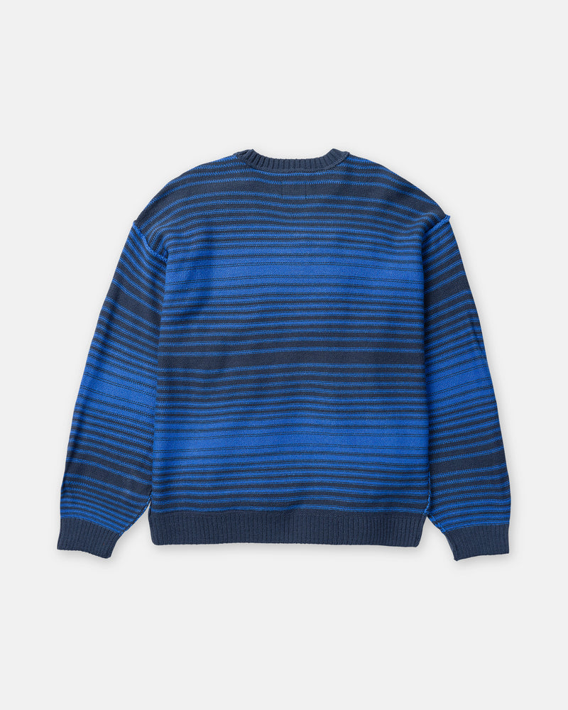 Back view of a Volcom Men’s Fade In Crew Sweater in Nebulas Blue, a wool-blend crewneck featuring horizontal stripes in shades of blue and black.