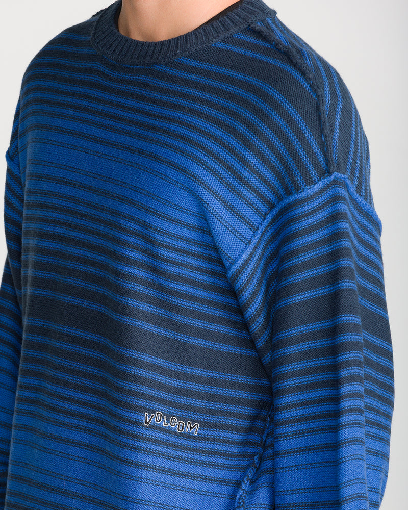 Volcom Men’s Fade In Crew Sweater in Nebulas Blue, featuring horizontal stripes in shades of blue and black, with a small brand logo embroidered near the lower hem.