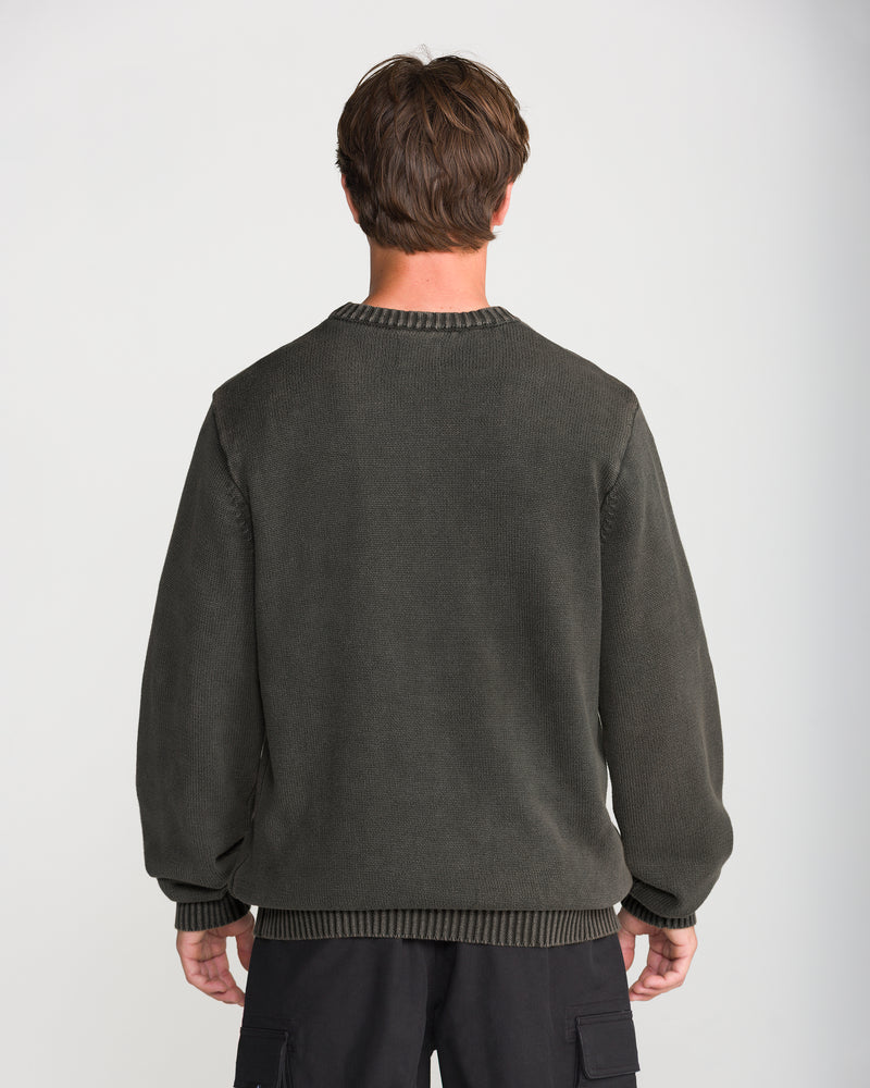A person seen from behind wears a Volcom Men’s Bleached Crew Sweater in charcoal gray, featuring a ribbed neckline and hem.