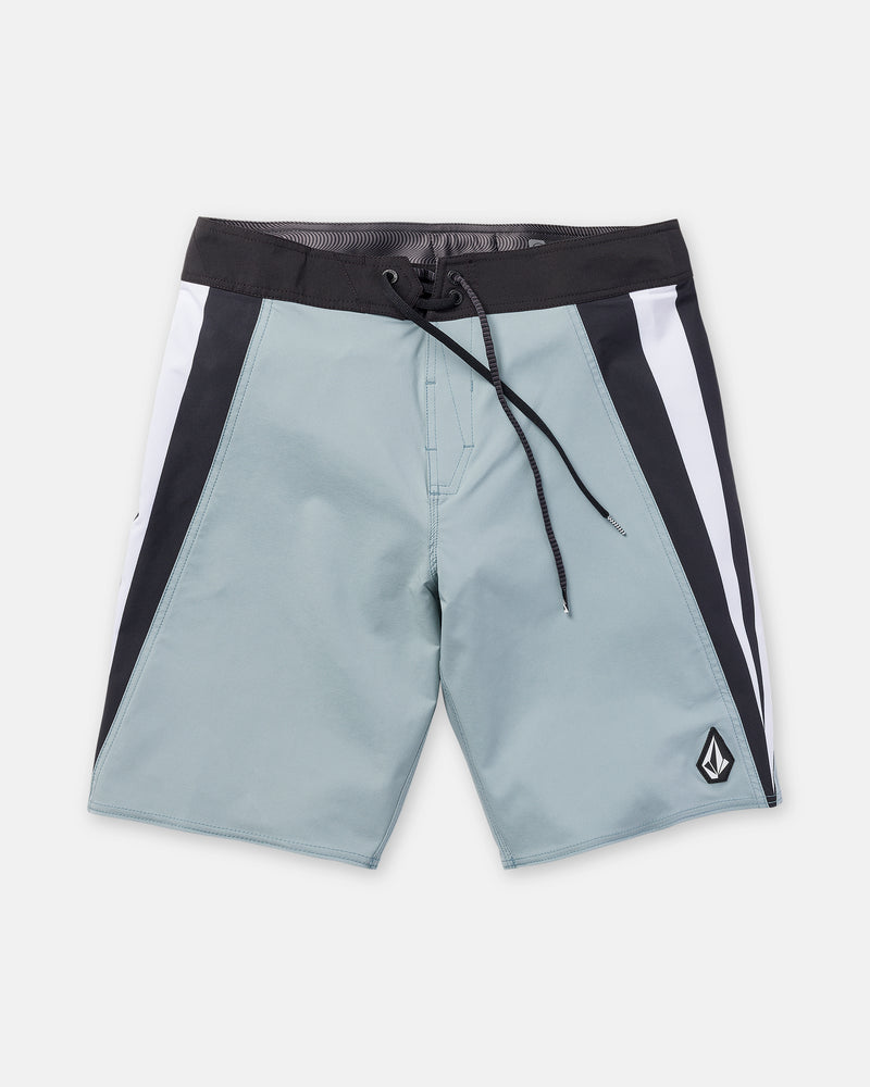 Laid flat on a plain background, the Volcom Men’s Facet Mod 20 boardshorts feature a light blue color with a contrasting black waistband, white and black side panels, 4-way stretch fabric for enhanced comfort, a drawstring closure, and a small logo patch on the lower left leg.