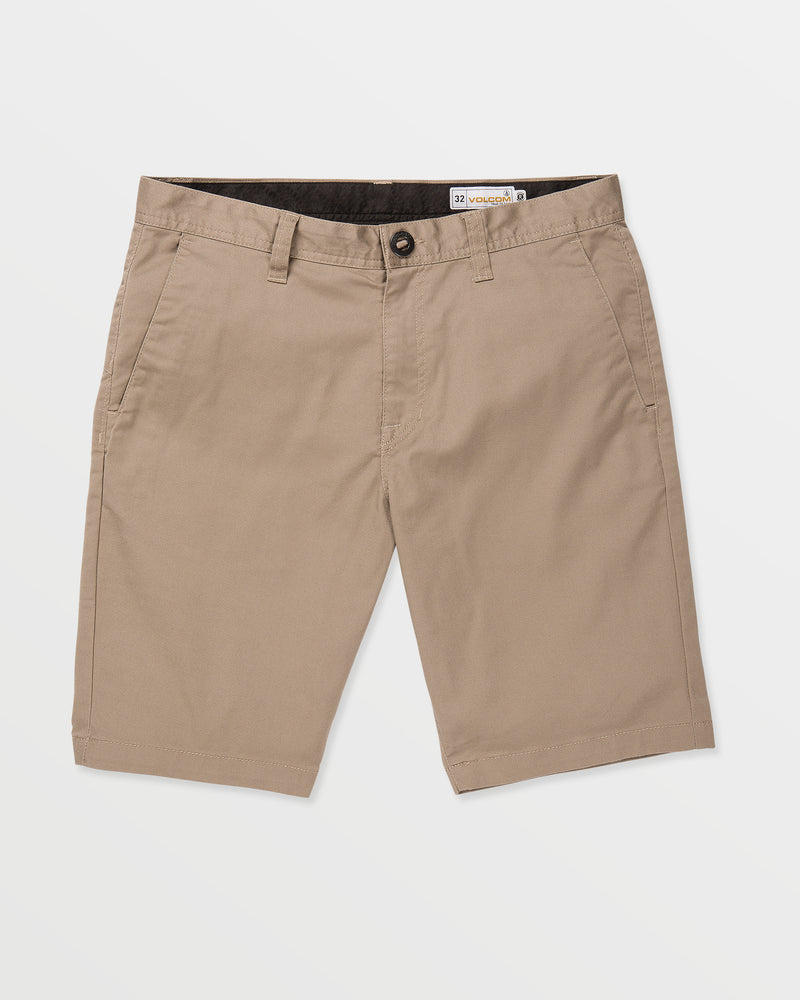 The Volcom Men's Frickin Modern Stretch 21" Shorts are light brown, knee-length chino khaki shorts with front pockets, belt loops, and button closure, made from modern stretch fabric and recycled fibers, shown on a white background.