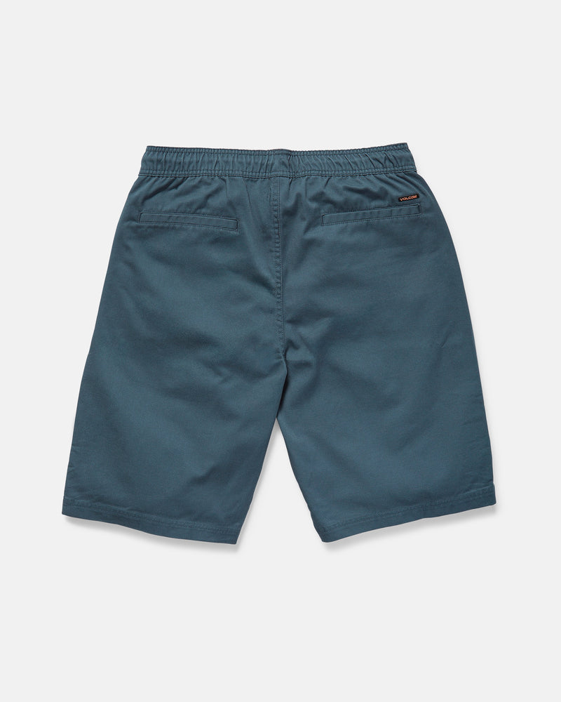 The rear view shows Volcom Men's Freazy Loose Elastic Waist 22" Shorts in blue-green corduroy with a 22-inch outseam, two back welt pockets, and a stitched logo tag on the right pocket against a plain white background.