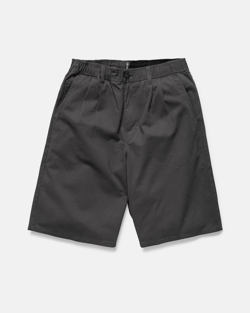 The Volcom Men's Chillow Plt Elastic Waist Chino 24" Shorts Vs are dark gray, baggy cotton twill shorts with an elastic waistband, belt loops, side pockets, and a button-zip closure, shown on a plain white background.