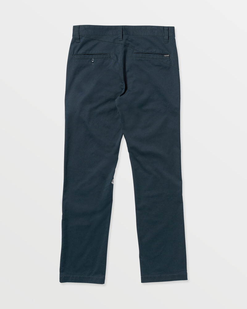 Volcom Men's Frickin Modern Stretch Pants in navy blue, shown from the back with two buttoned back pockets and belt loops, made with recycled polyester stretch twill, displayed on a white background.