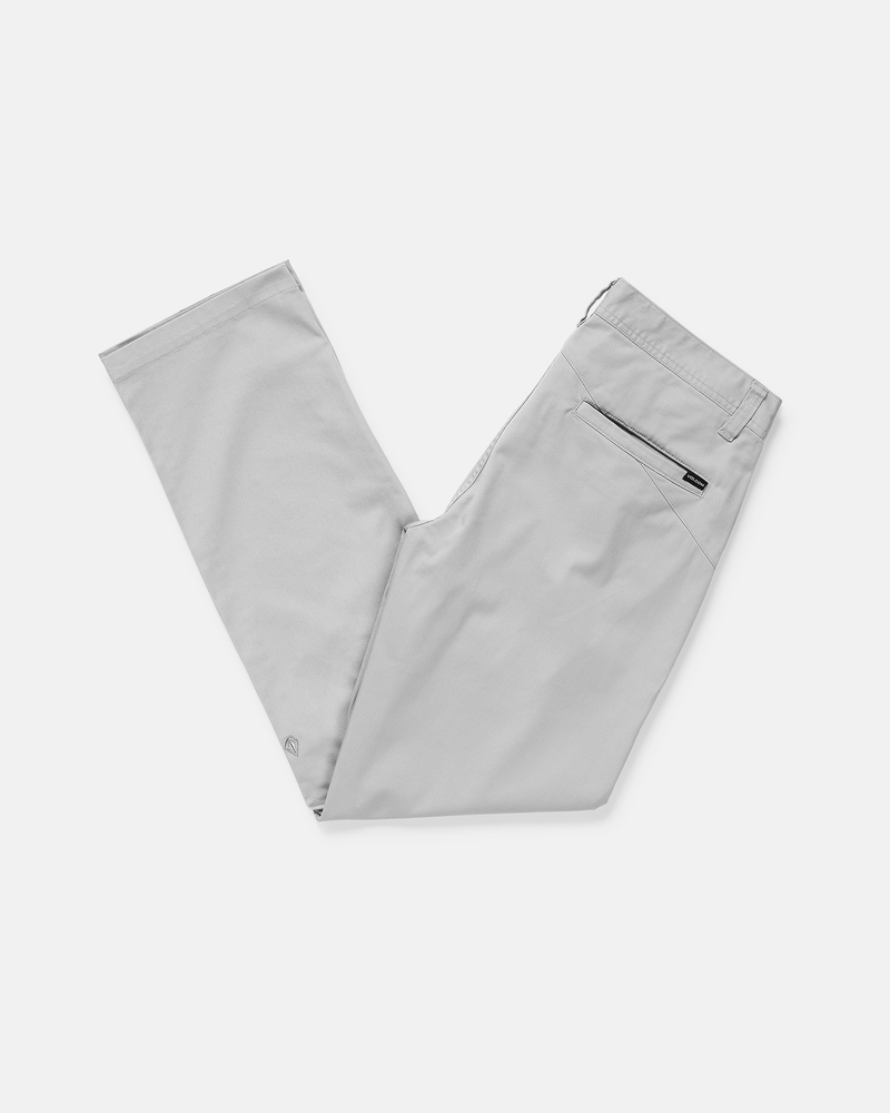 Men's Frickin Modern Stretch Pants by Volcom in light gray, made from recycled polyester, folded to show the black zipper pocket on the back right side and placed on a plain white background.