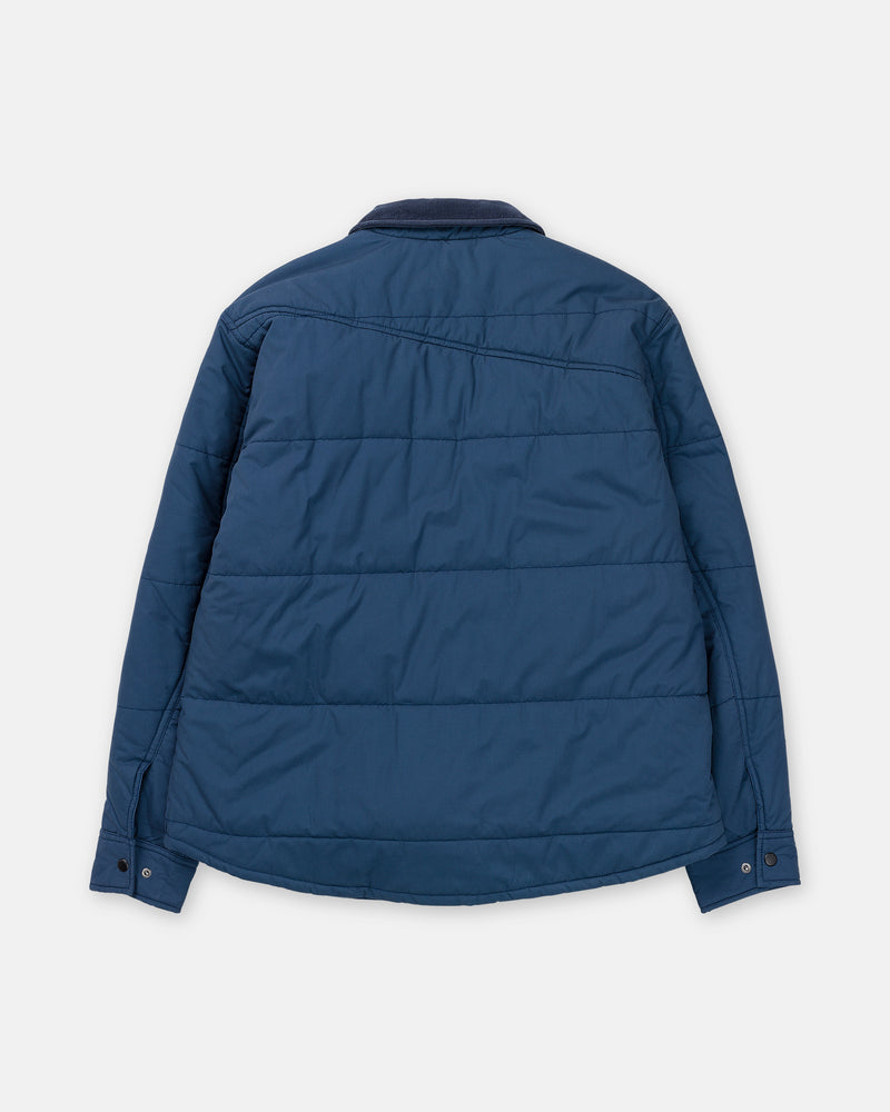 Back view of a blue, quilted Volcom Men’s Westshore Jacket with a corduroy collar and button cuffs.