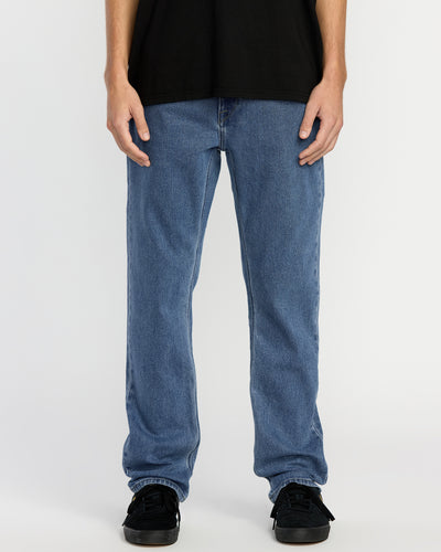 A person wearing a black t-shirt, Men's Solver Denim in Deep River Blues, and black sneakers stands against a plain white background. The image is cropped from the shoulders down.