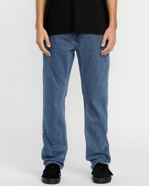 A person wearing a black t-shirt, Men's Solver Denim in Deep River Blues, and black sneakers stands against a plain white background. The image is cropped from the shoulders down.