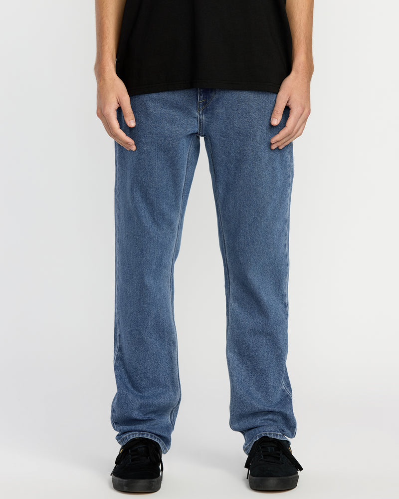 A person wearing a black t-shirt, Men's Solver Denim in Deep River Blues, and black sneakers stands against a plain white background. The image is cropped from the shoulders down.