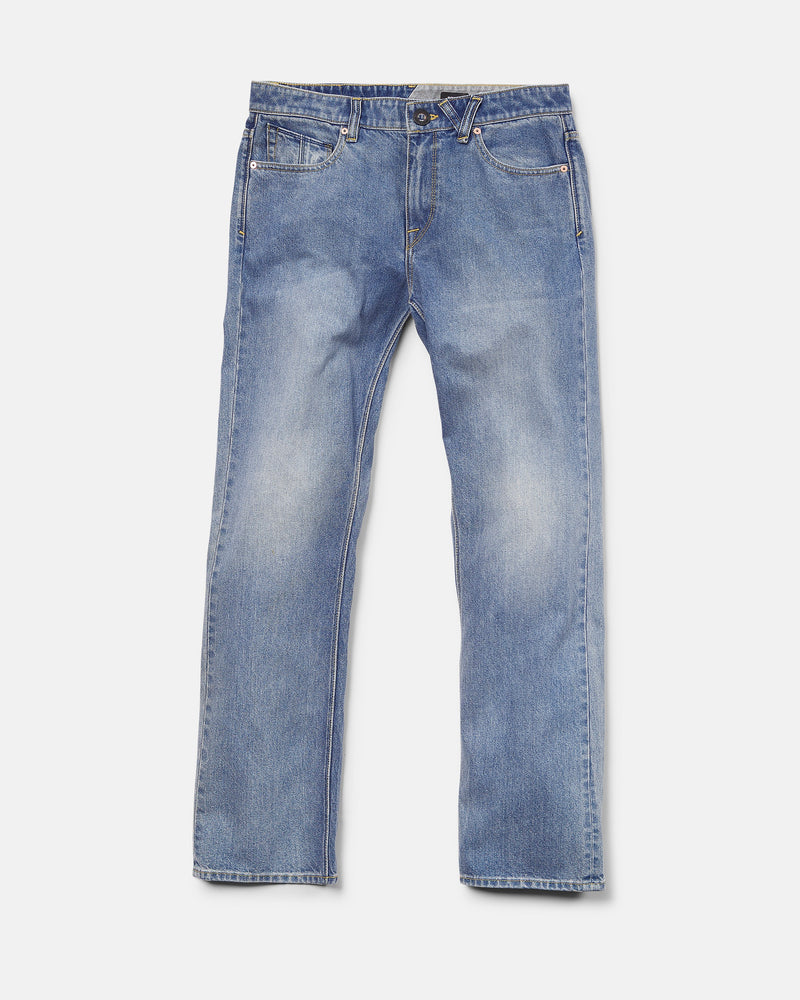 A pair of Volcom Men's Solver Denim Pants in Freedom Blue, featuring a modern straight leg cut, crafted from soft stretch denim with front pockets, belt loops, and a button closure, laid flat on a white background.