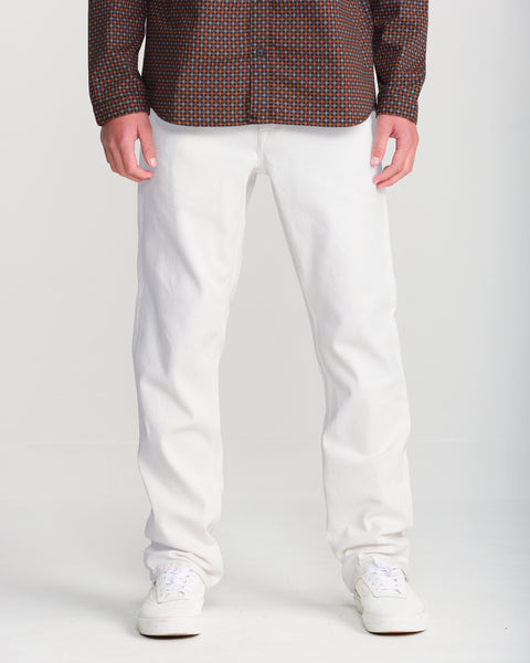 A person wearing a checkered button-down shirt, white Men’s Solver Denim, and white sneakers.
