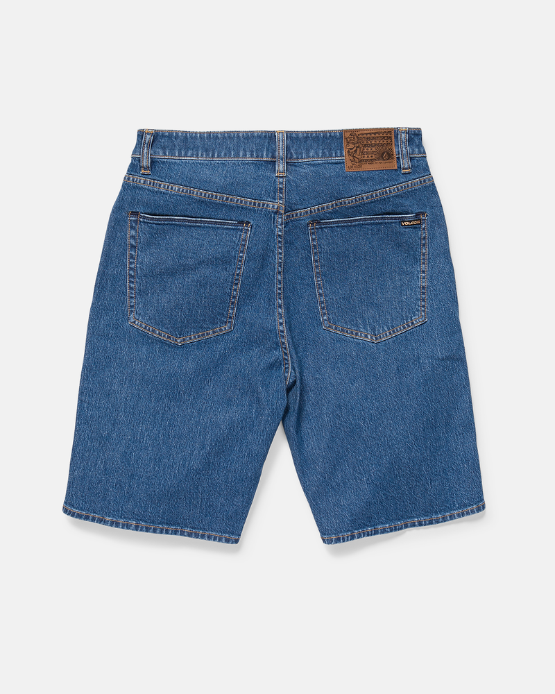 Back view of Volcom Men's Billow Denim Short 22 in blue, featuring two rear pockets and a brown leather patch on the waistband, laid flat on a white background.
