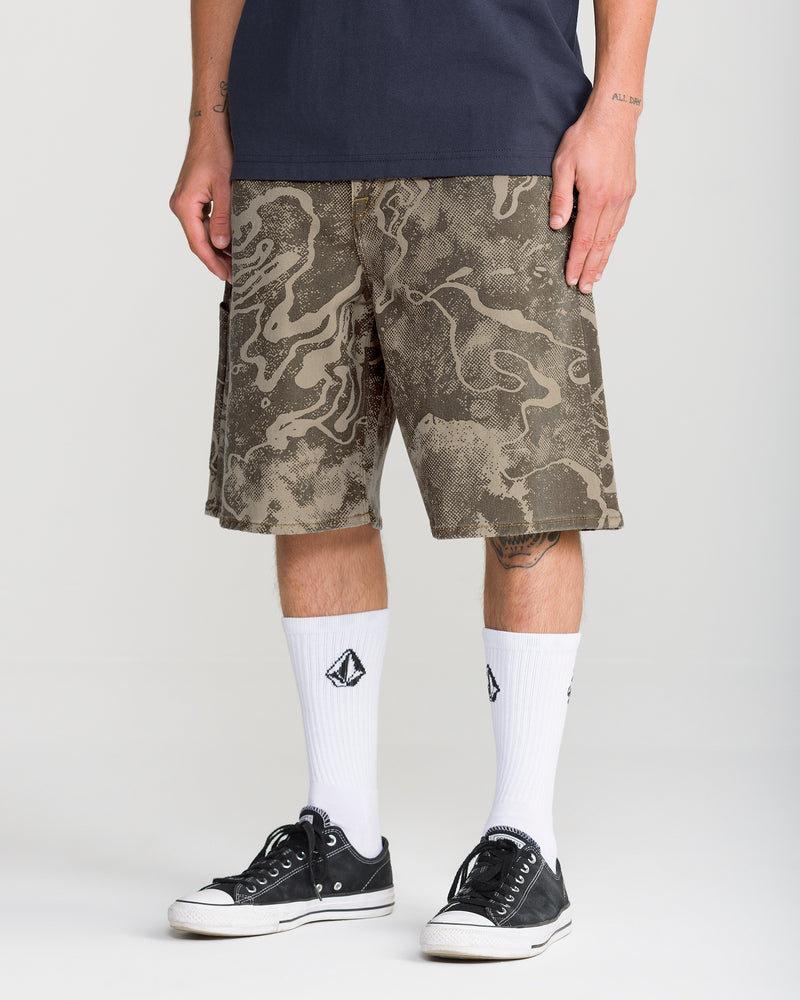 Olive green Men’s Kinkade Utility Denim Short 22 with an abstract tonal print, worn with white crew socks and black low-top sneakers.