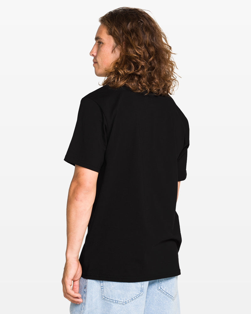 A person with long wavy hair, wearing a plain black t-shirt and light blue jeans, stands facing away and slightly to the side against a plain white background.