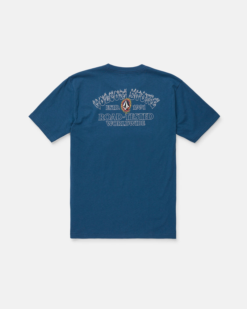 The Volcom Men's Ringafire Short Sleeve Tee, shown from the back in blue, is crafted from premium ring spun cotton for a soft, durable feel. This heavy-weight t-shirt features decorative white and blue "Road-Tested Worldwide" text, a small graphic, and additional branding above and below it.