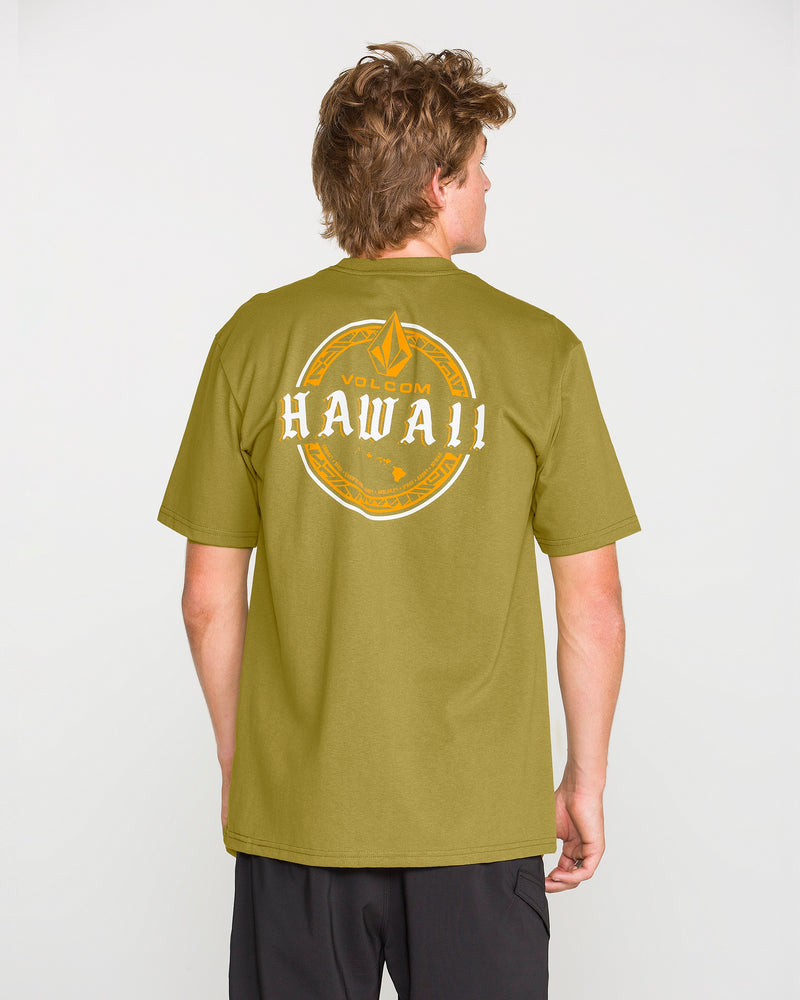 A person wearing a Volcom Men’s Island Time Short Sleeve Tee in olive green, featuring “HAWAII” and a circular logo on the back, stands facing away from the camera against a plain white background.