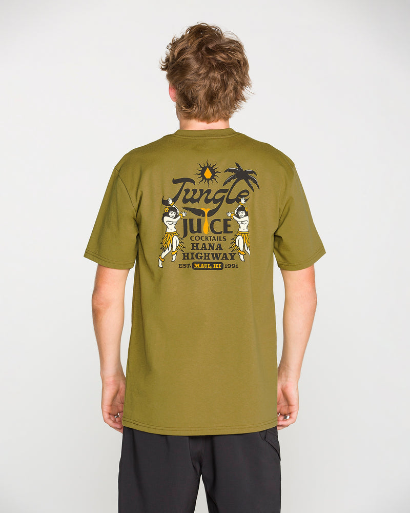 Wearing the Volcom Men’s Jungle Juice Short Sleeve Tee in olive green, which features a “Hana Highway” print and a graphic of two hula dancers, a sun, and a palm tree on the back, a person stands against a plain background. Crafted from premium ring-spun cotton, this classic fit T-shirt delivers both comfort and style.