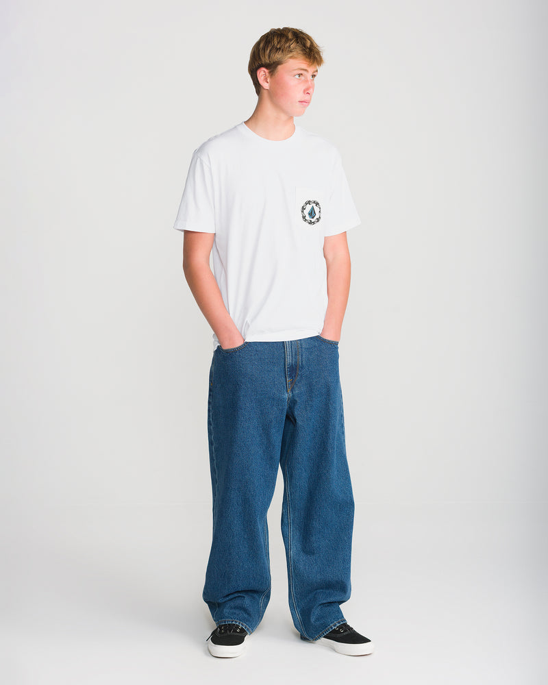 A person wearing a Volcom Men’s Twister Short Sleeve Tee, a heavyweight classic fit pocket t-shirt with a small graphic on the chest, and loose-fit blue jeans.