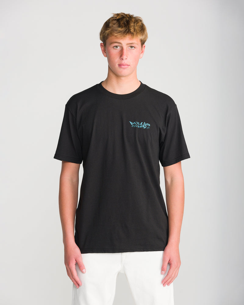 A young man wearing a black Volcom Men’s Framer Short Sleeve Tee featuring a classic fit, short sleeves, a crew neck, and a small blue logo on the left chest.