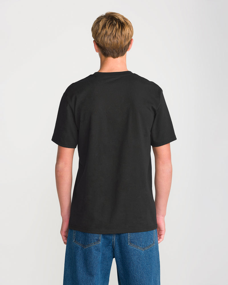 A person with short, light brown hair is standing with their back to the camera against a plain white background, wearing blue jeans and the Volcom Men’s Full Stone Short Sleeve Tee in black.